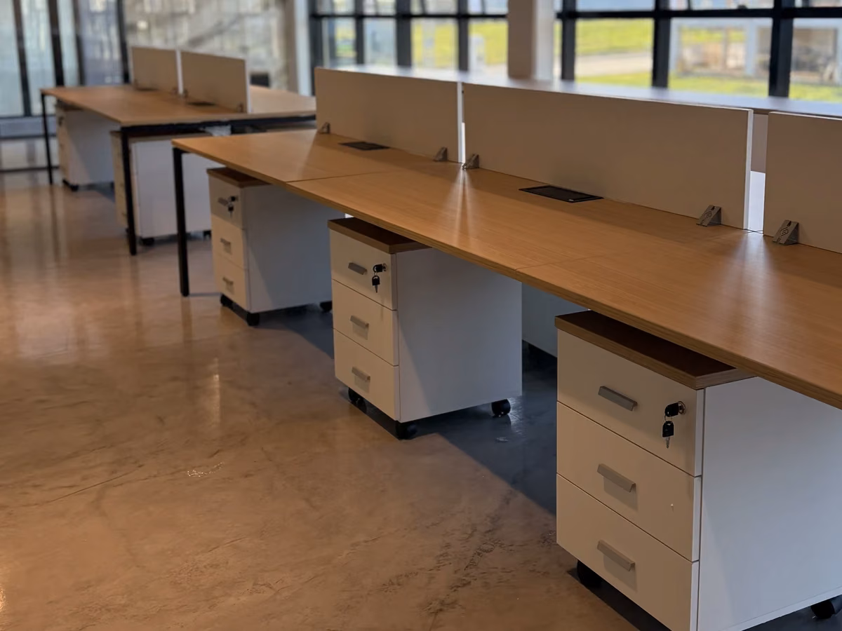 Puestos de trabajo con escritorios de madera y cajoneras